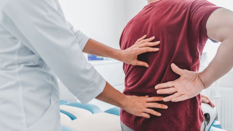 Main with back pain being examined by doctor