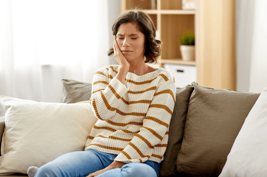 Woman holding her jaw due to TMJ pain