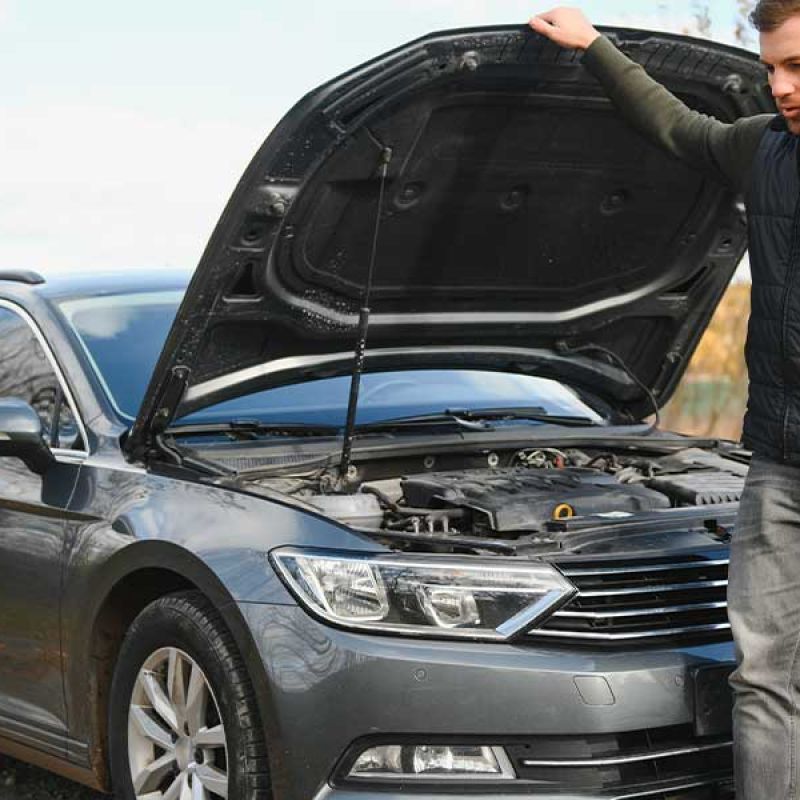 man calling for roadside assistance after his car broke down.