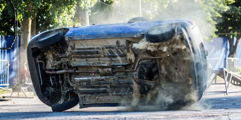 a car that is sitting in the street after a rollover accident and with visible damage