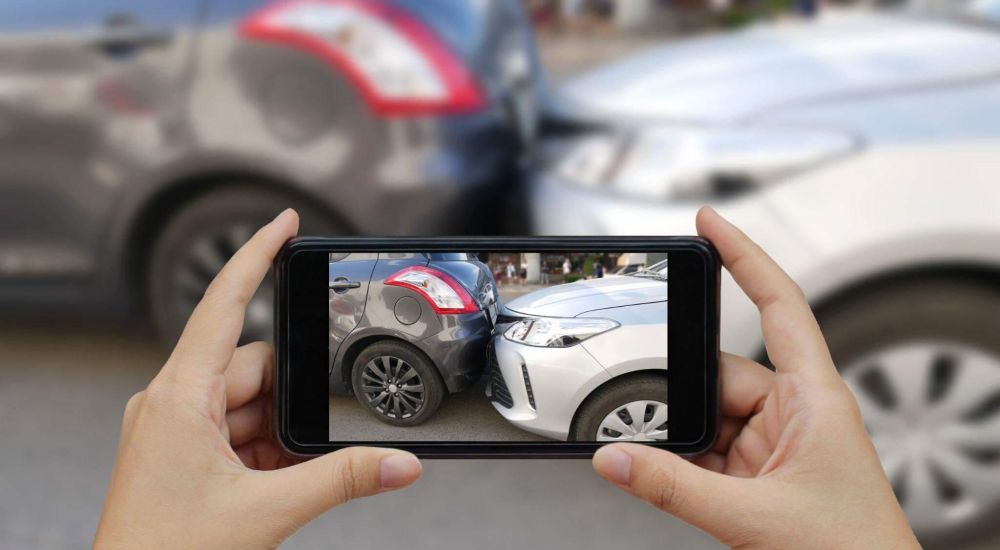 Person photographing two cars at accident site