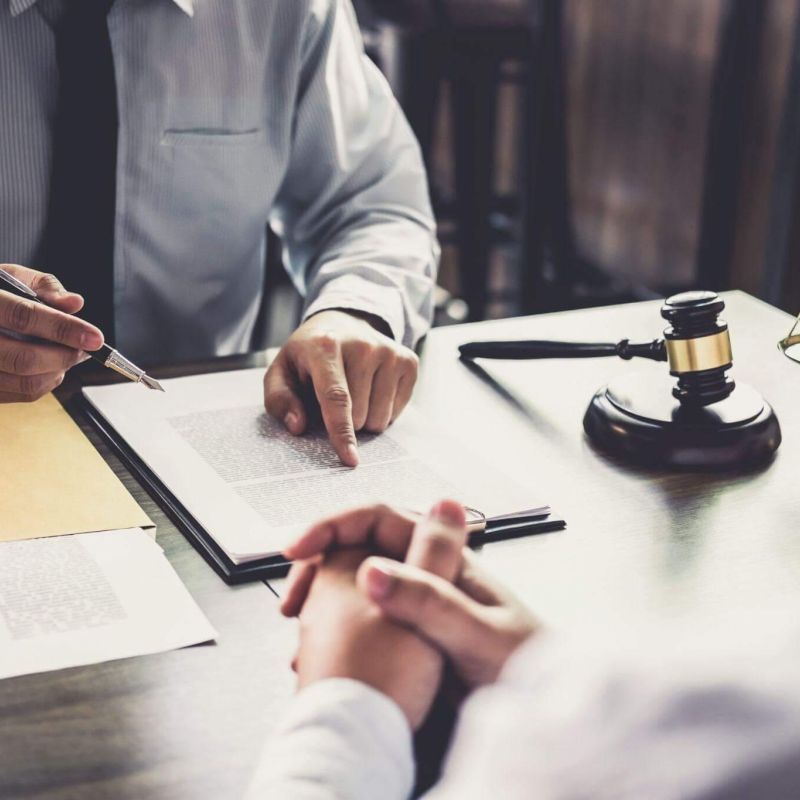 two people sitting at a table in front of a judge