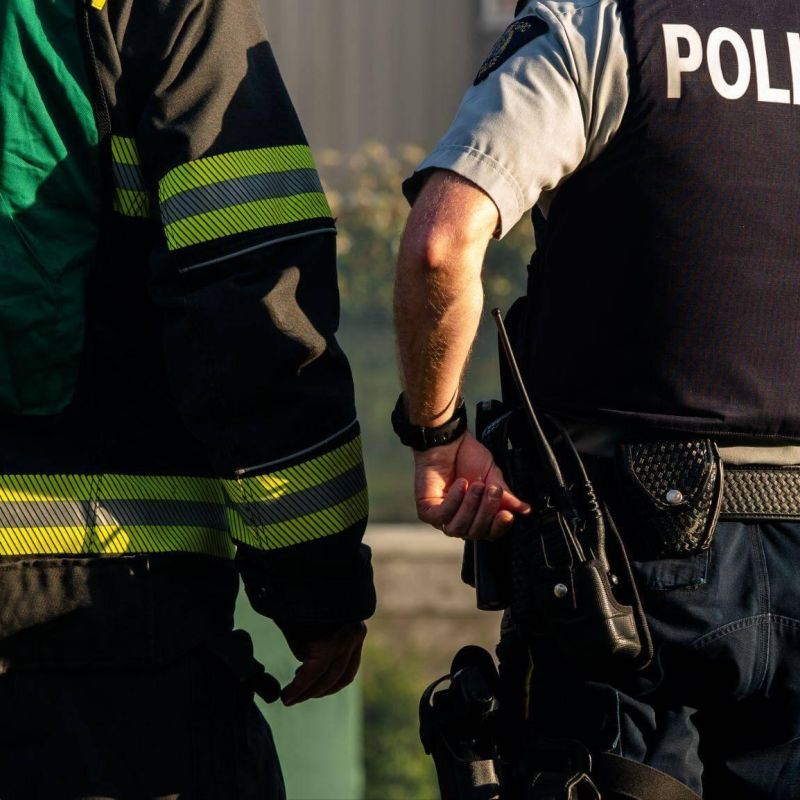 Two first-responders standing next to each other, one is a fireman and the other a police officer