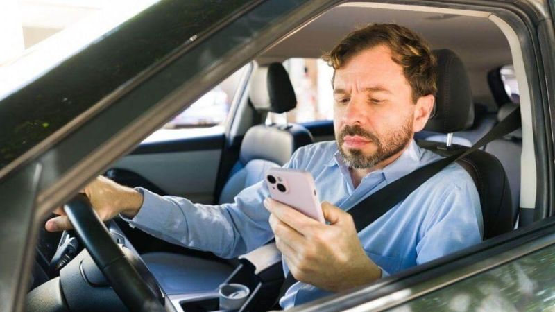 A man in a car using a cell phone