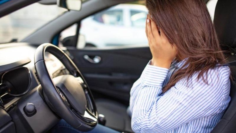 Woman in car looking uncertain, perhaps post-accident