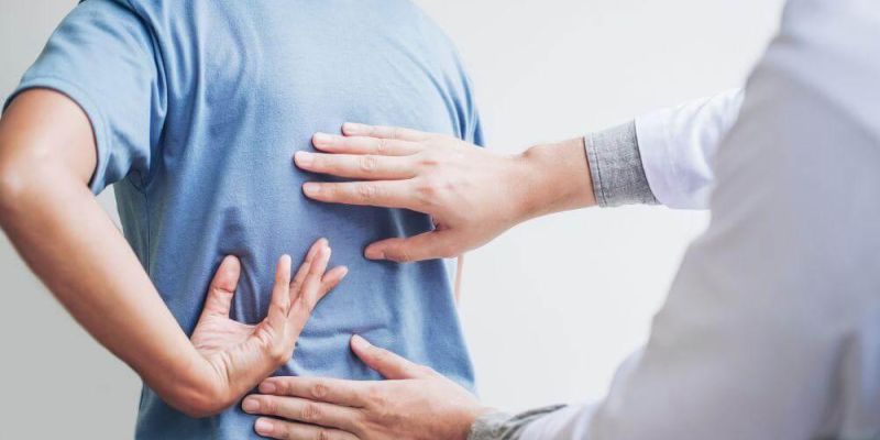 Man holding his back in pain while considering chiropractic