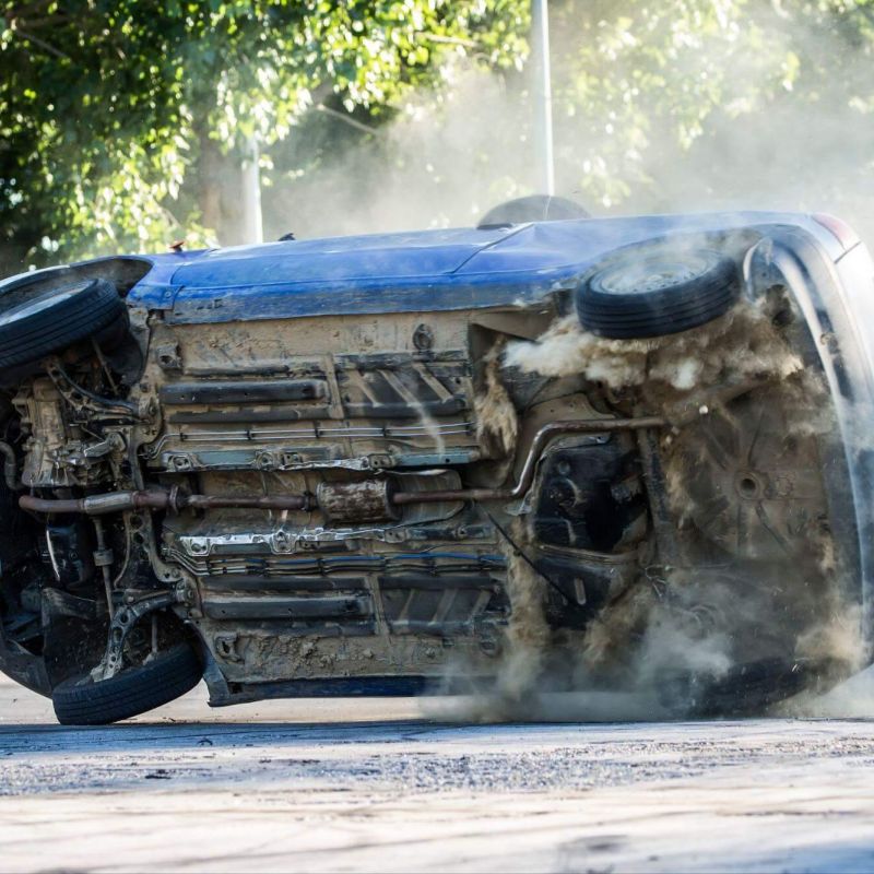 a car that is sitting in the street after a rollover accident and with visible damage
