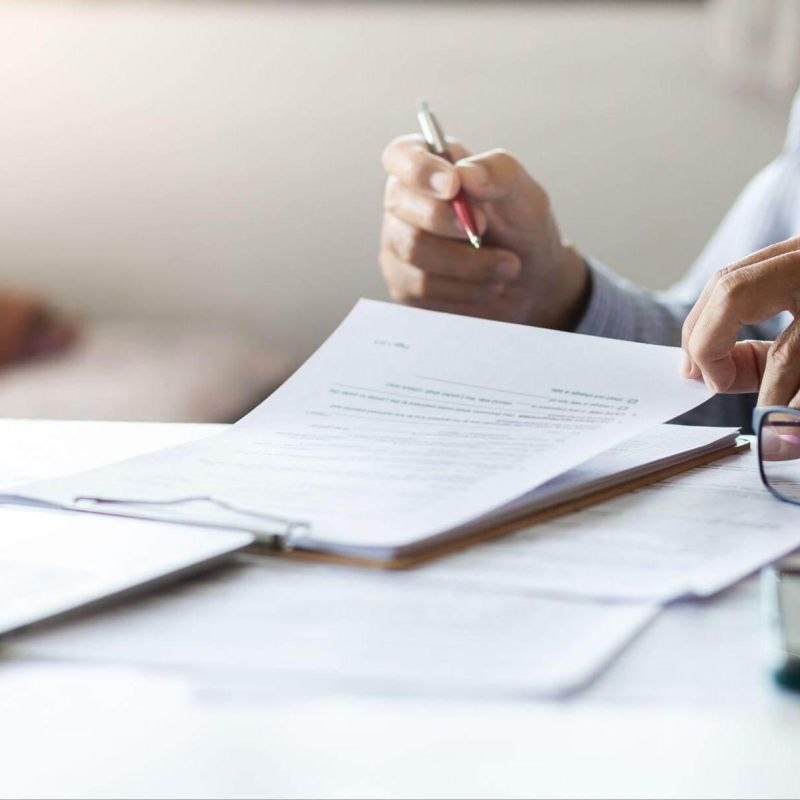Man writing at desk with pen and paper