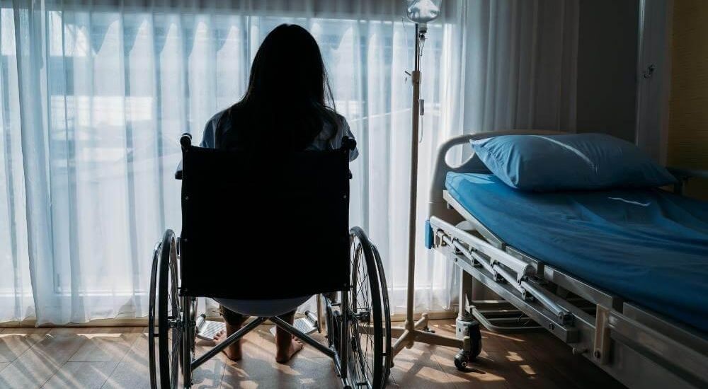 Woman in a wheelchair experiencing emotional distress after