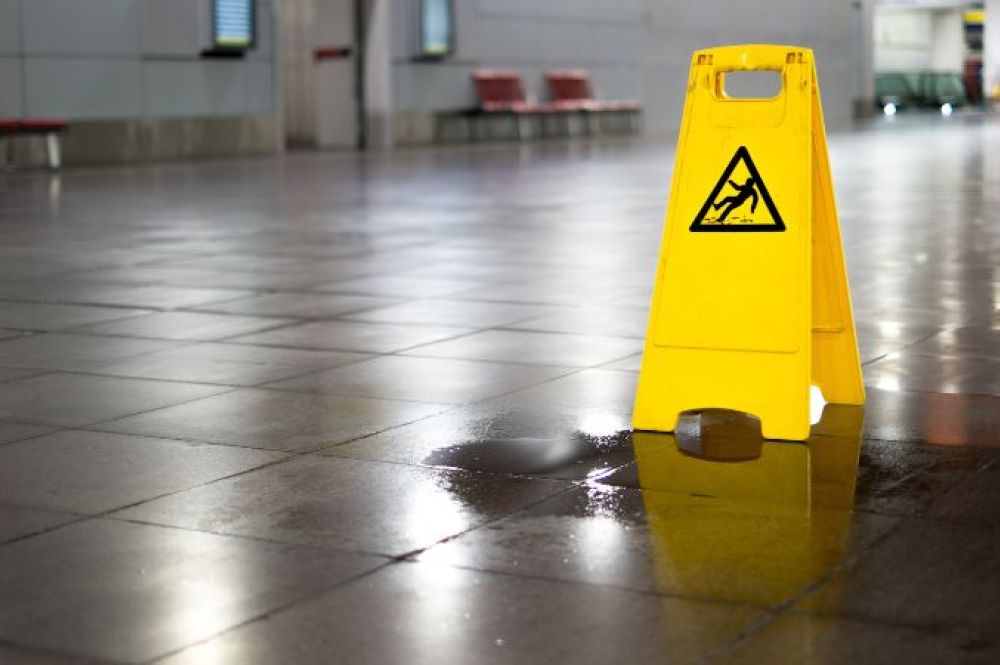 Slip hazard warning tent on wet tile floor