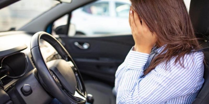 Woman in car looking uncertain, perhaps post-accident