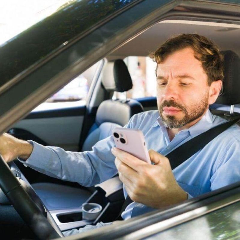 A man in a car using a cell phone