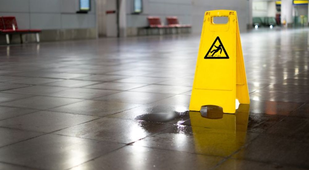 Slip hazard warning tent on wet tile floor