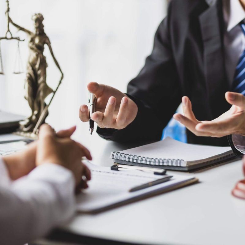 two people sitting at a table in front of a laptop