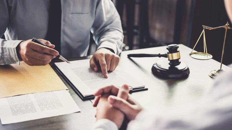 two people sitting at a table in front of a judge