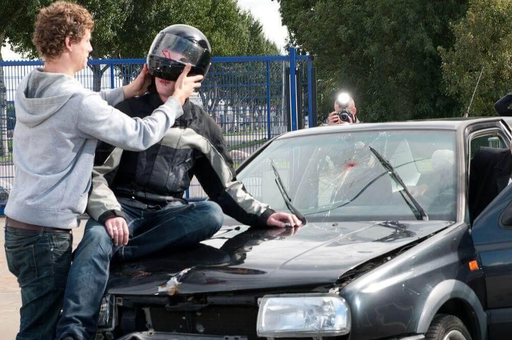 Two men sitting on the hood of a car