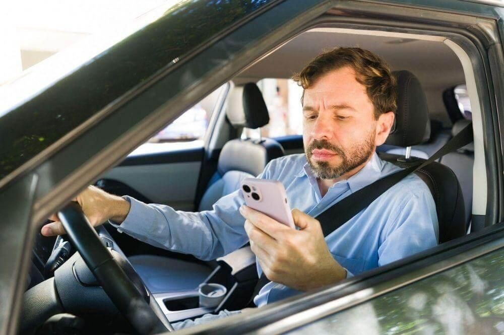 A man in a car using a cell phone
