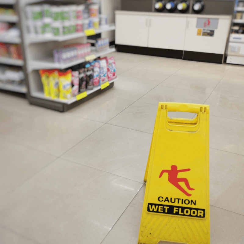 yellow wet floor sign on floor in store
