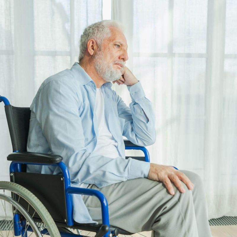 a man sitting in a wheelchair in front of a window