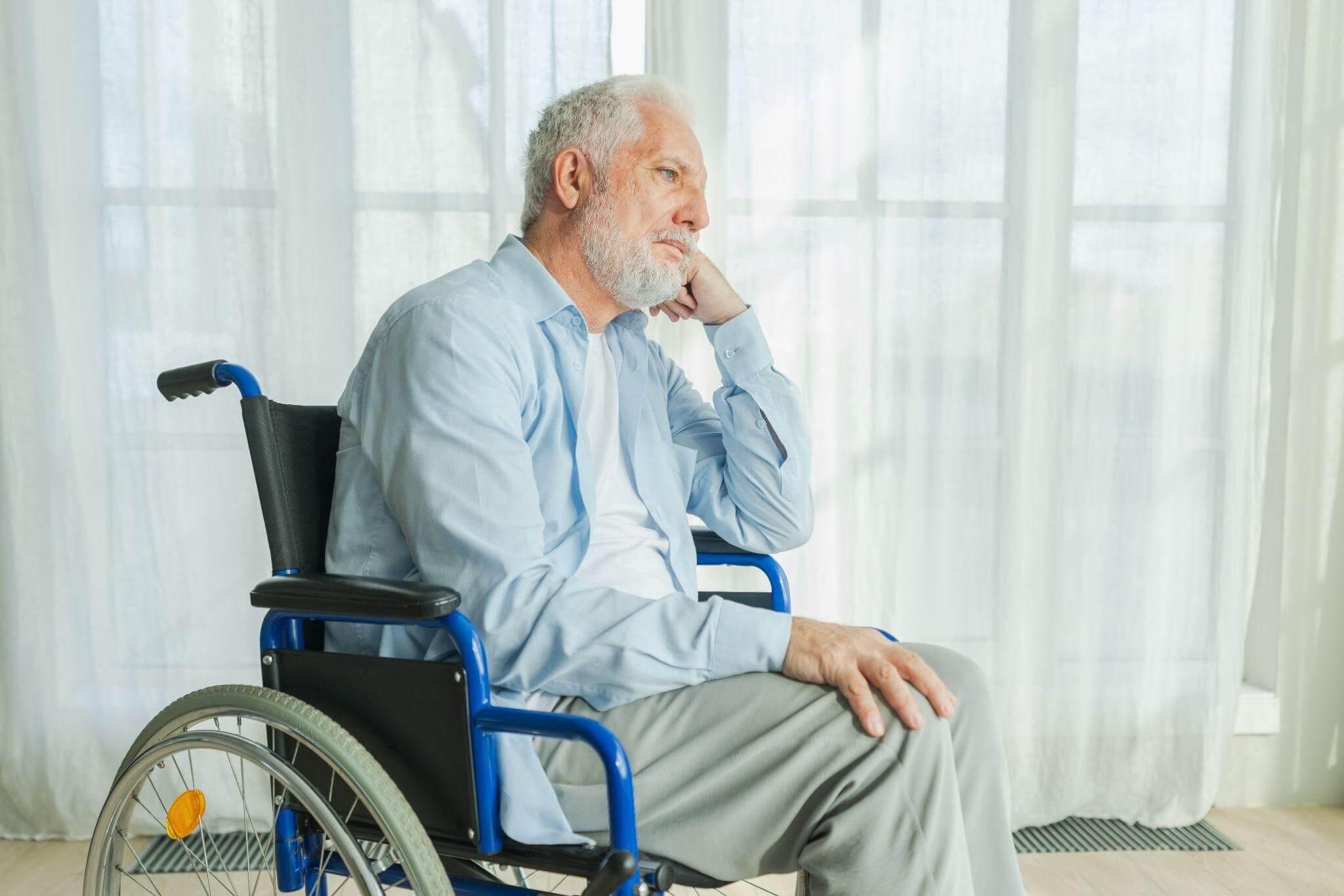 a man sitting in a wheelchair in front of a window
