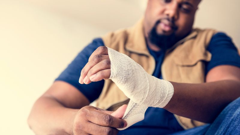 Man wrapping his wrist in a bandage