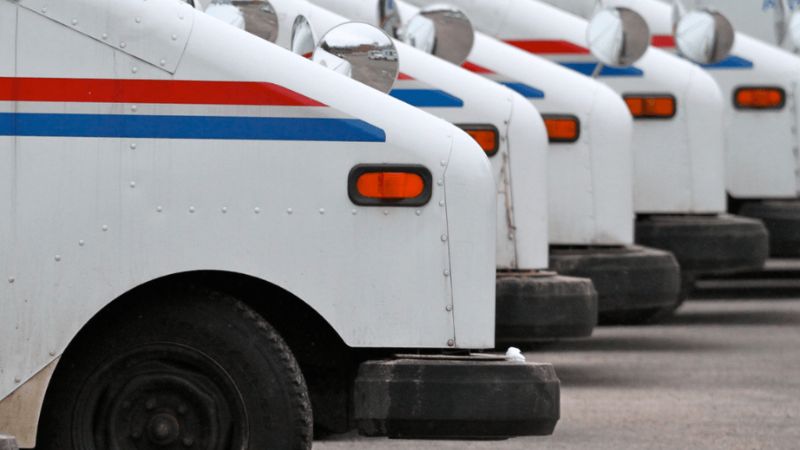 A row of USPS government mail trucks
