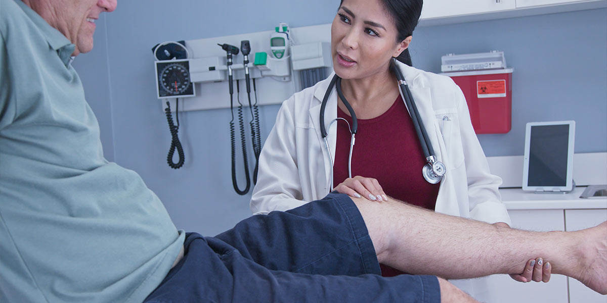 A doctor looking at a patients leg