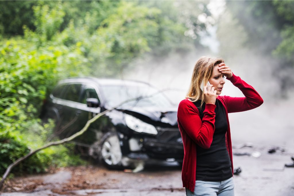 Woman on phone standing in front of car