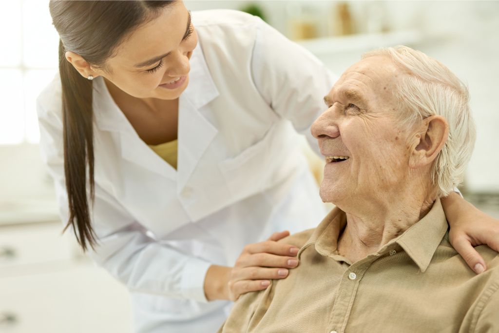 Happy elderly man smiling at a doctor