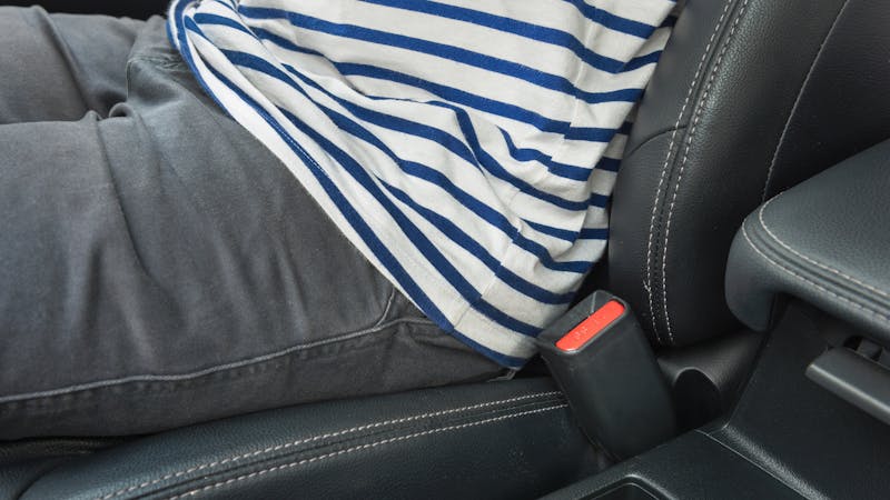 boy sitting in passenger seat without a seat belt