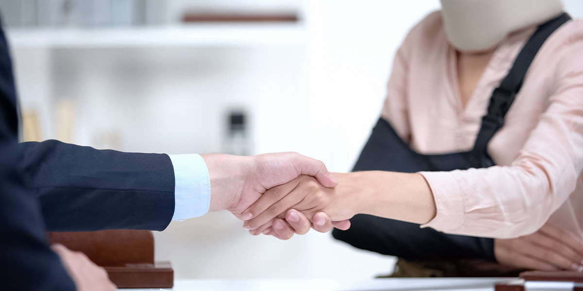 | Matz Injury Law an injured woman shaking hands with a lawyer