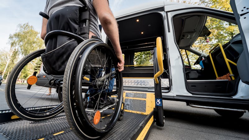 | Matz Injury Law A person in a wheelchair is boarding a van equipped with a ramp, highlighting accessible vehicle transportation.