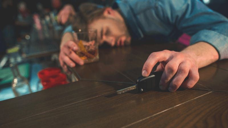 man passed out with alcohol in one hand and car keys in other. 