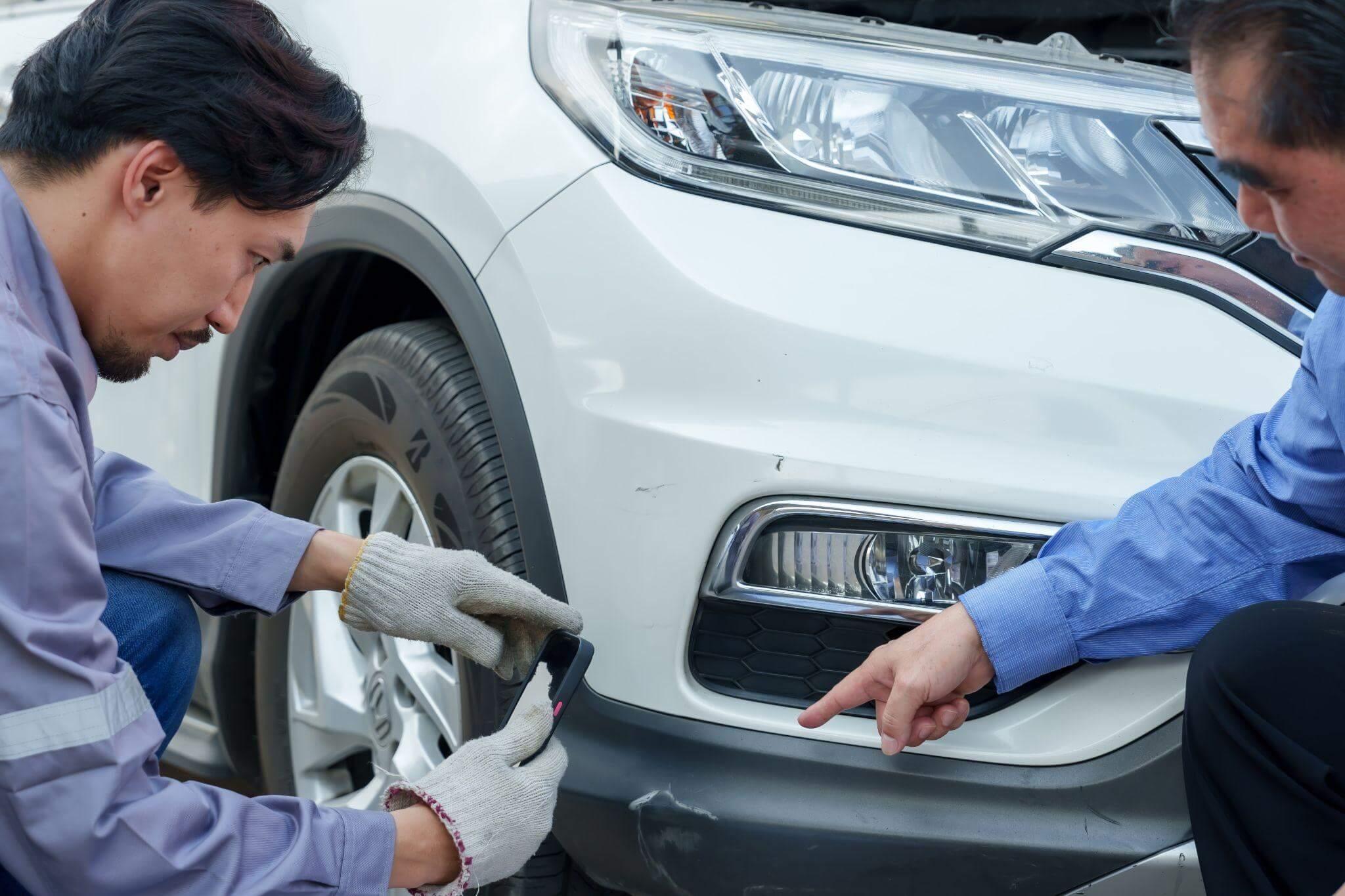 Two men repairing car tire during settlement process