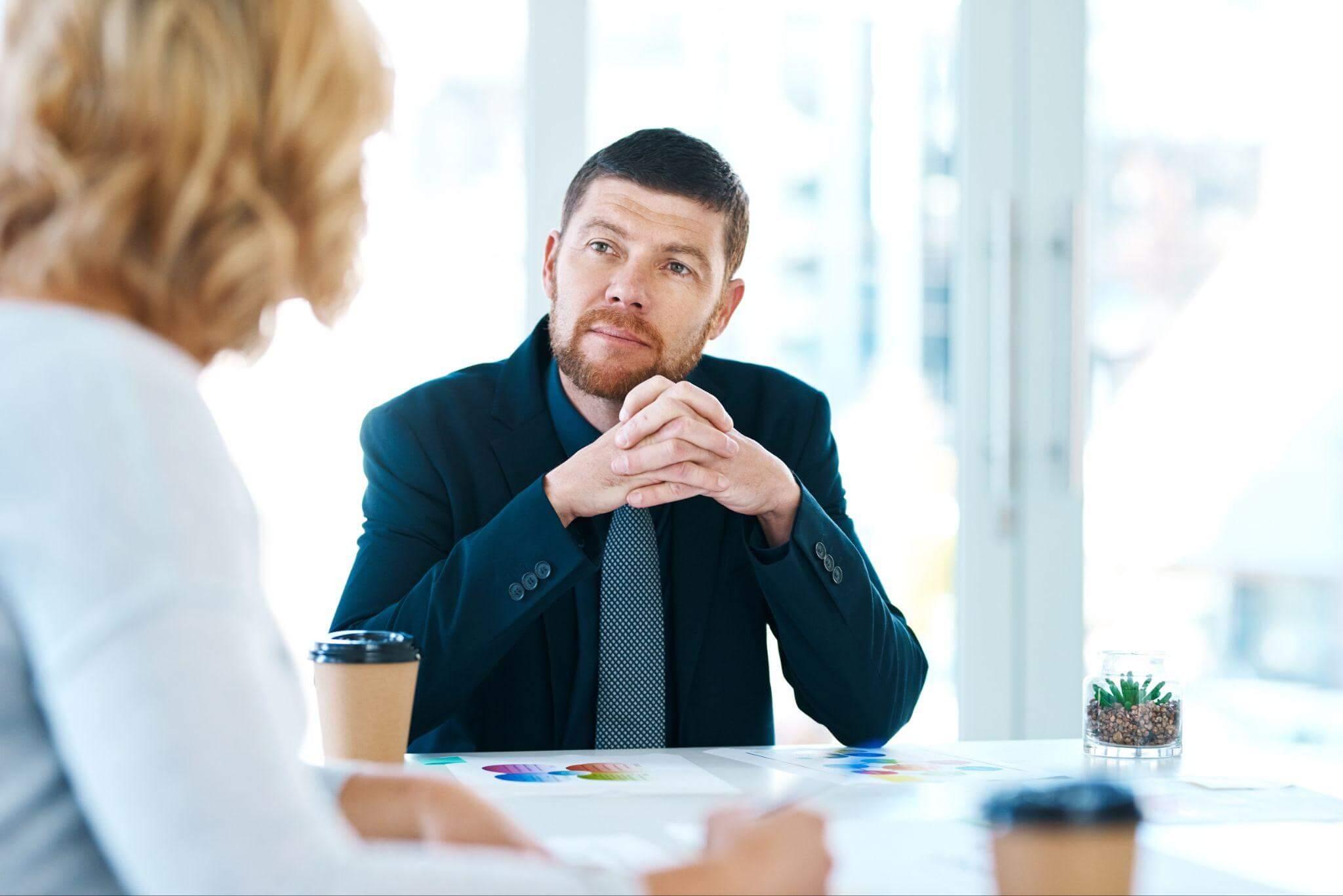 a man sitting at a table in front of a woman