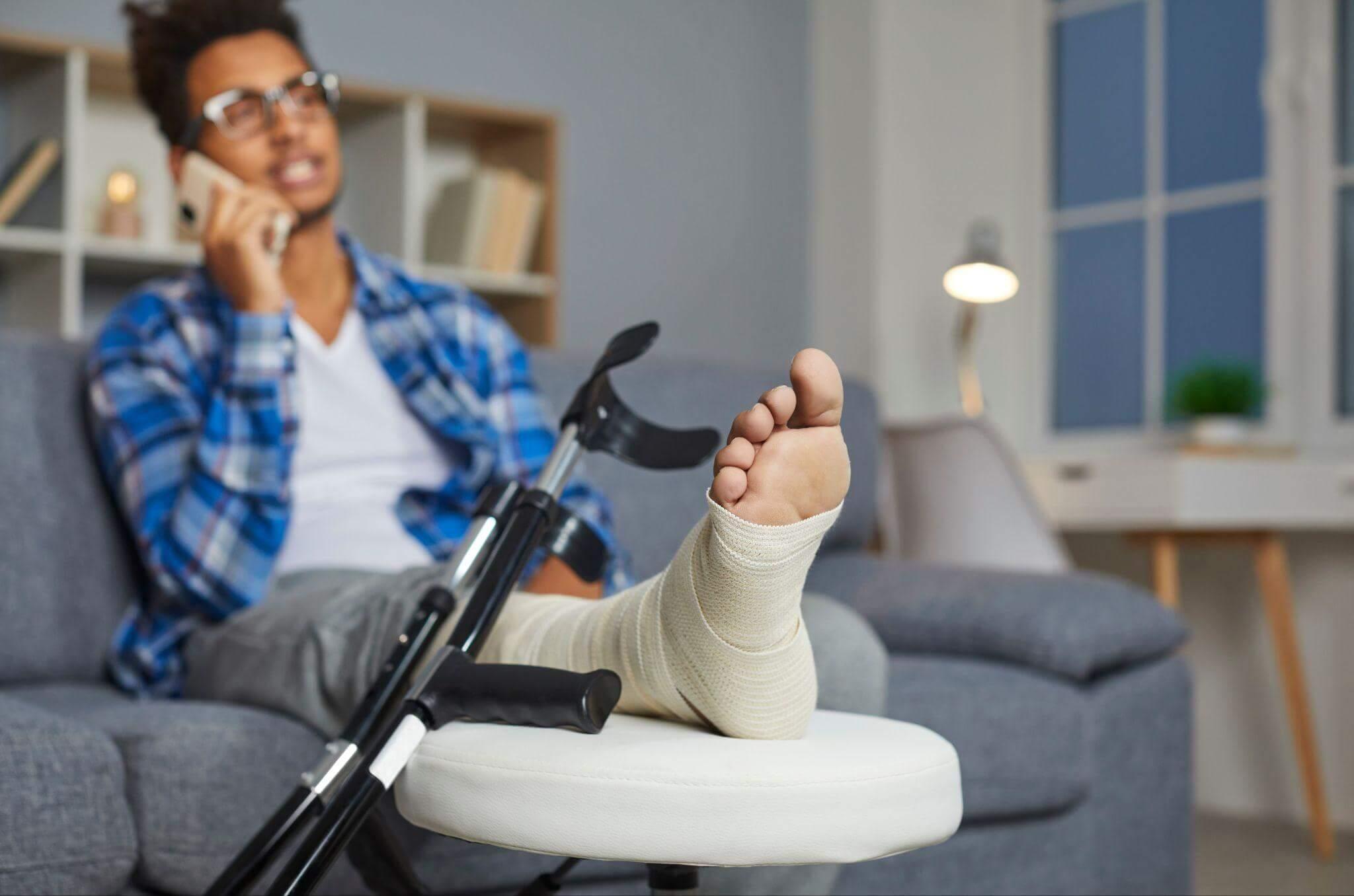 a man sitting on a couch with a cast on his foot