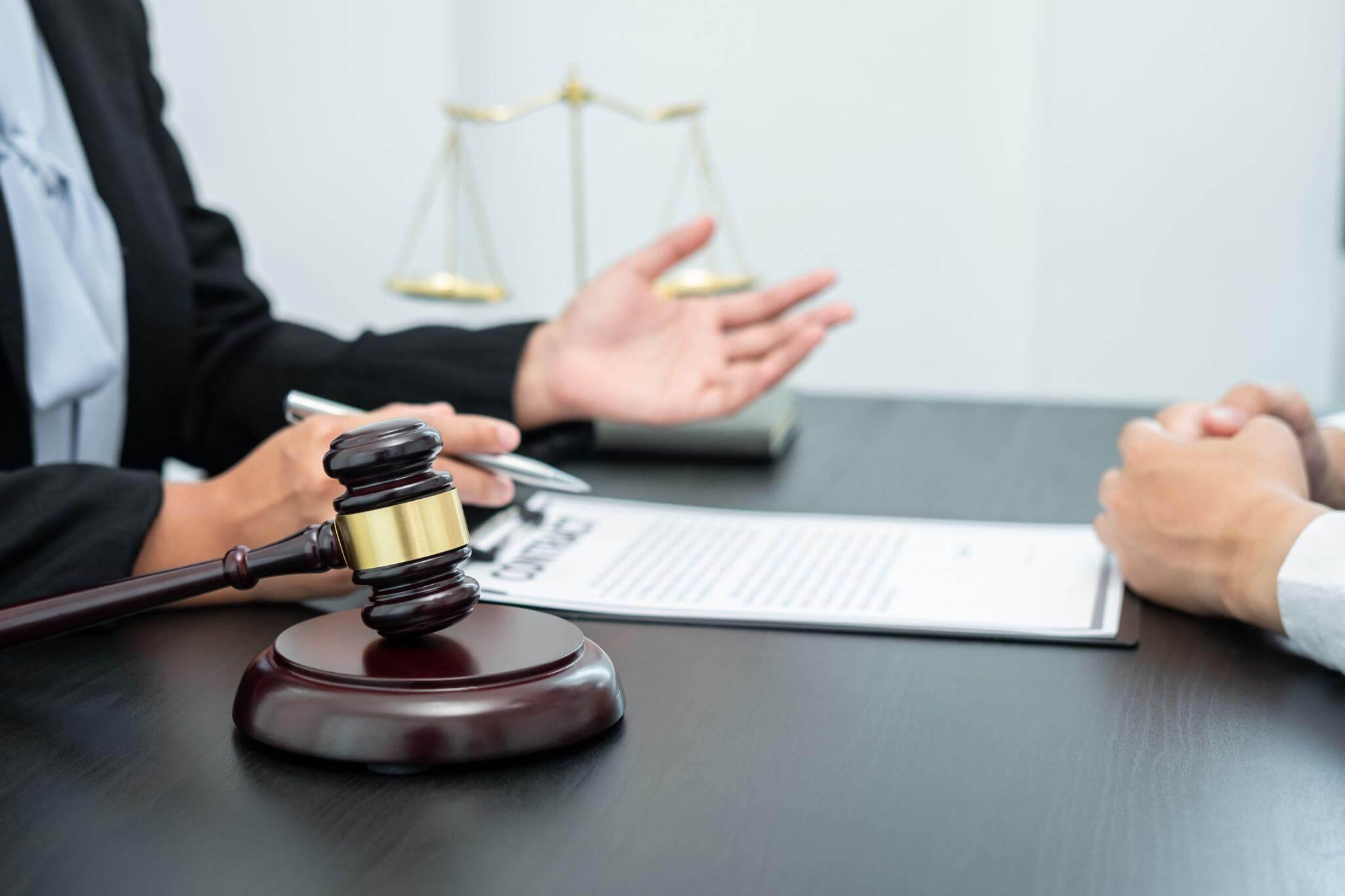 two people sitting at a table in front of a judge