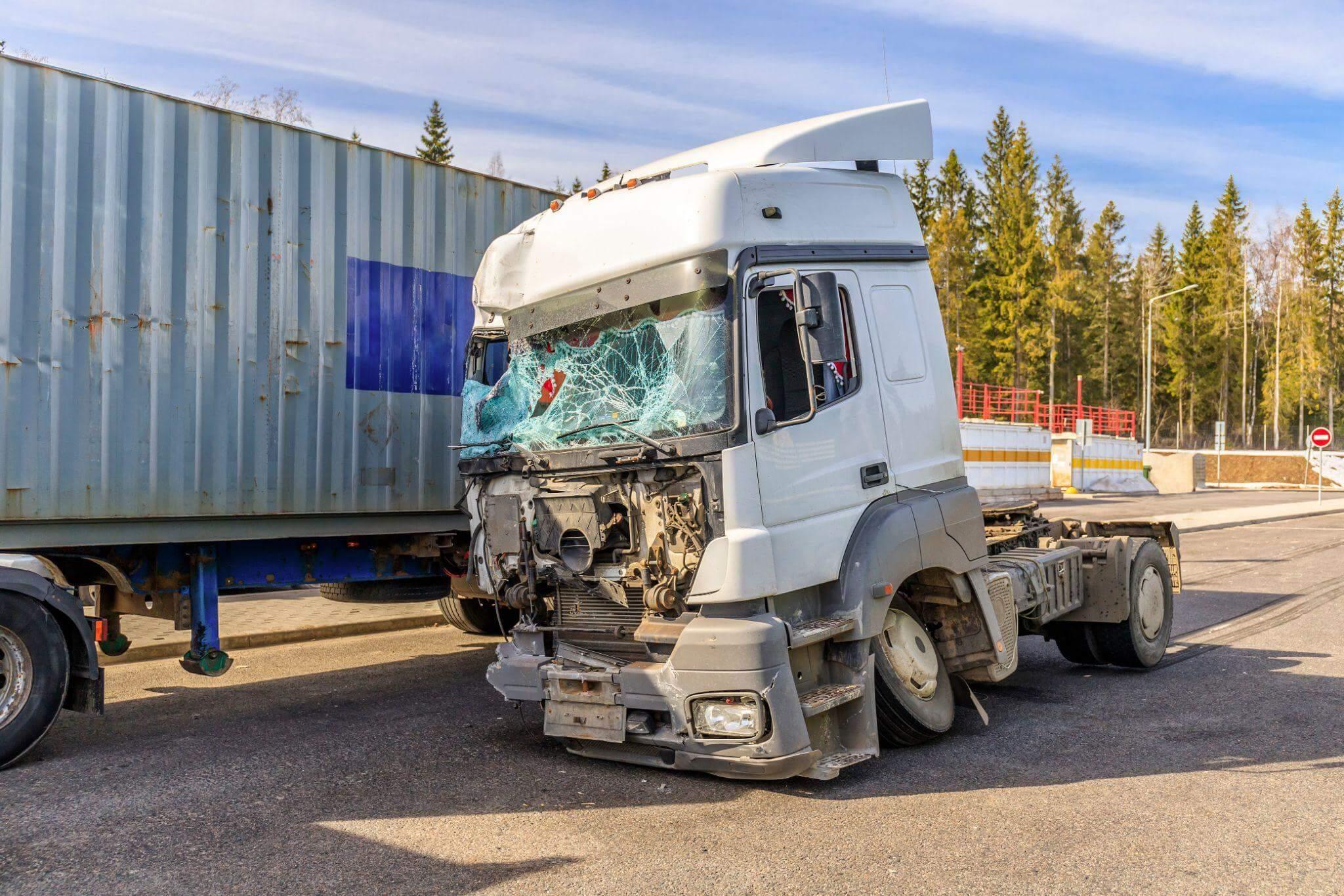 a white semi truck with a broken windshield