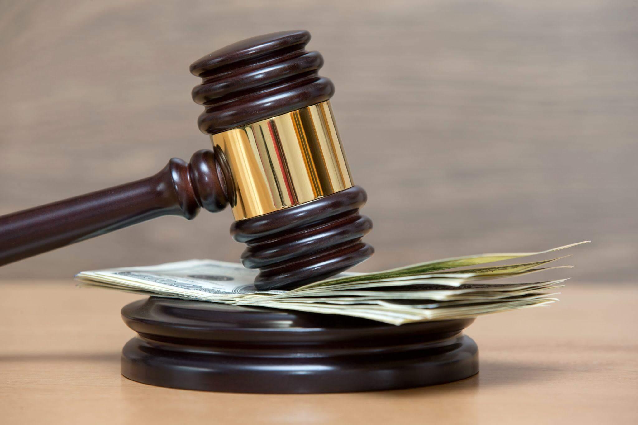 judge's hammer on top of a pile of money