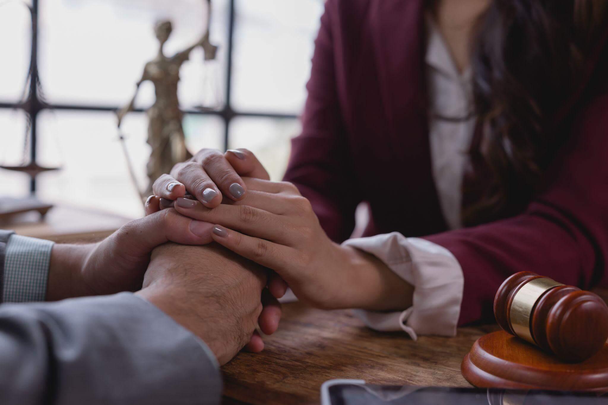 two people holding hands over a wooden table