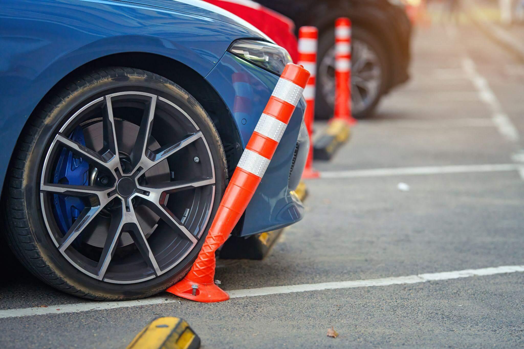 a blue car parked in a parking lot next to orange cones