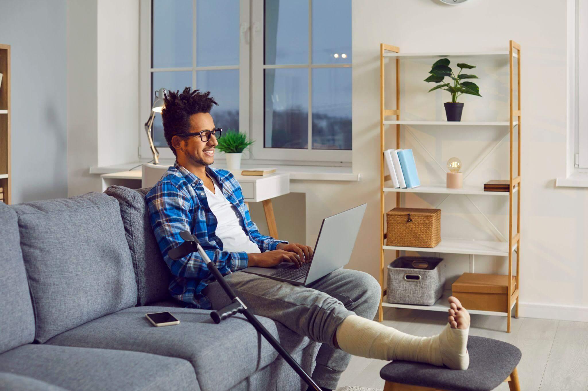 a man sitting on a couch with a cast on his leg