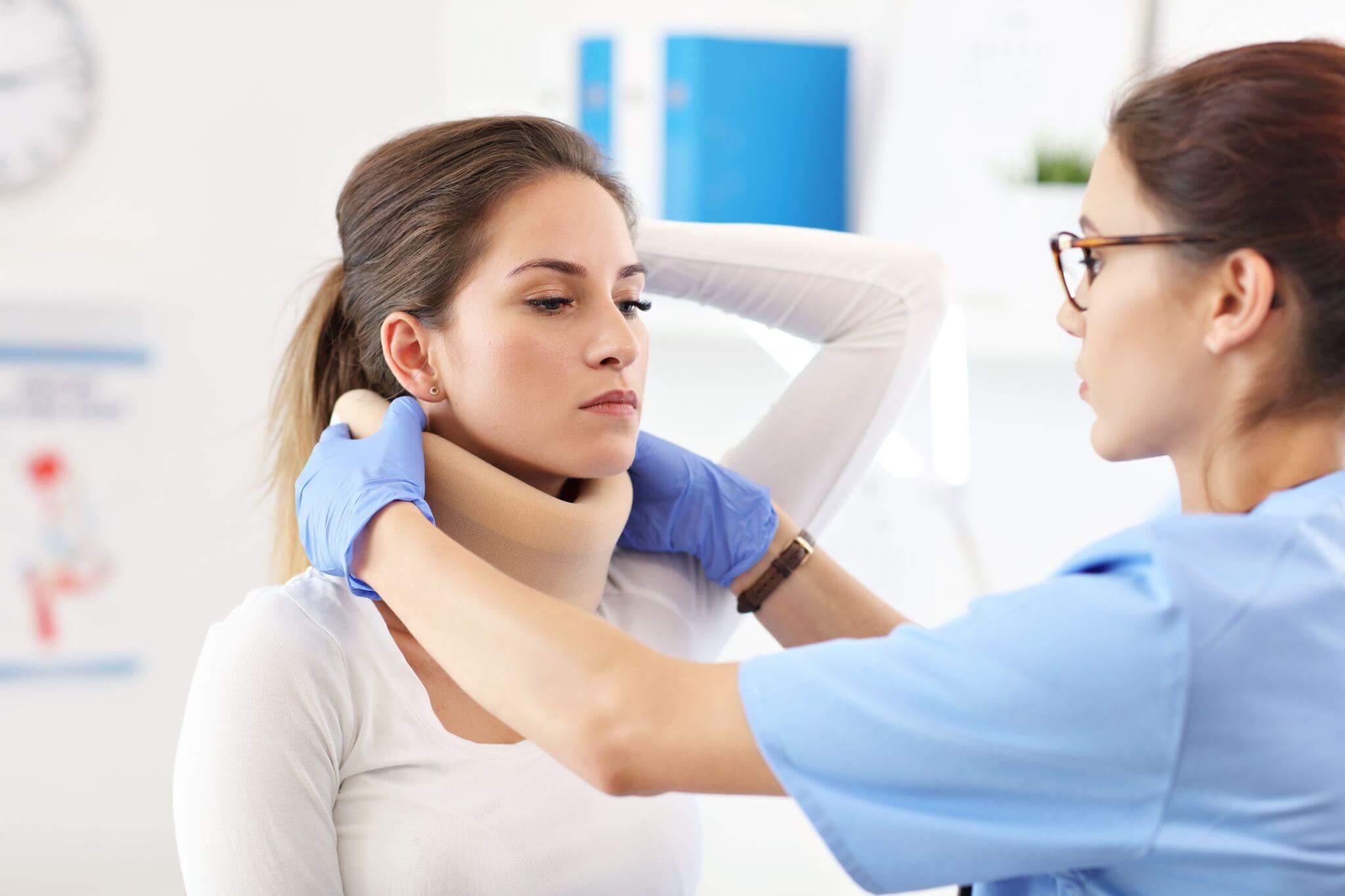 a woman getting her neck examined by a doctor