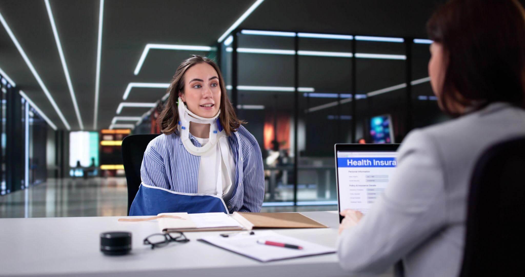 a woman sitting at a desk talking to another woman
