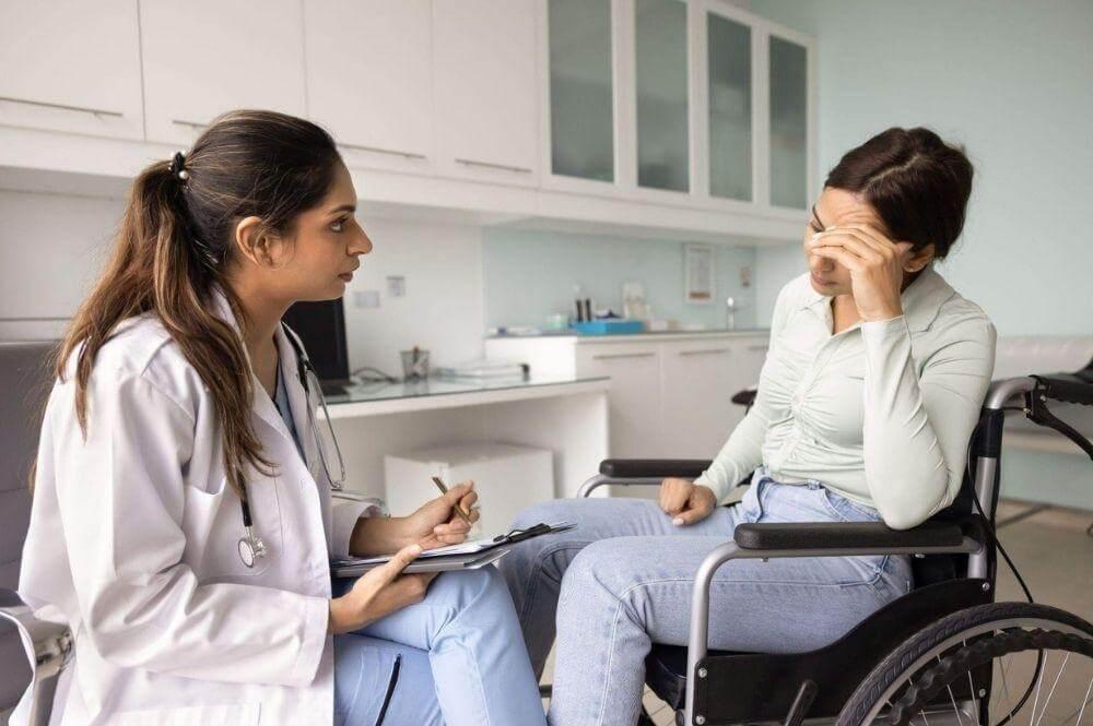 Woman in wheelchair discusses trauma with doctor