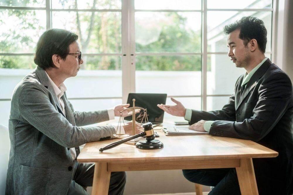 Two men discuss a client review for car accidents